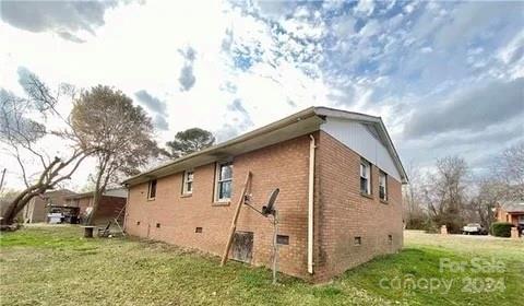 view of side of home with a lawn