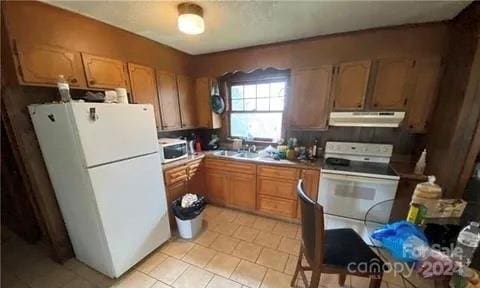 kitchen featuring light tile patterned flooring and white appliances