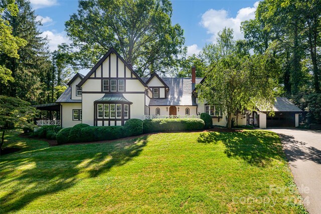 tudor-style house featuring a front lawn