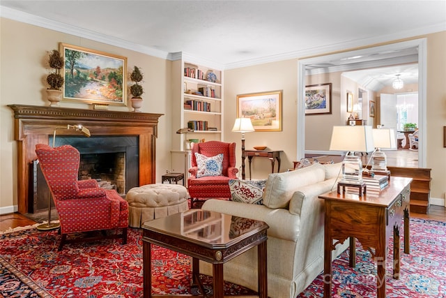 living area with ornamental molding, wood-type flooring, an inviting chandelier, and built in shelves