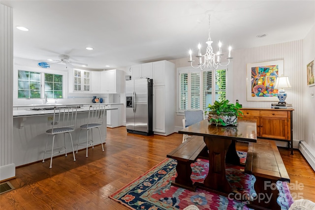 dining room featuring dark hardwood / wood-style flooring and ceiling fan with notable chandelier