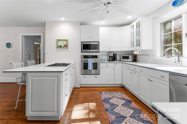 kitchen with stainless steel appliances, white cabinetry, and a breakfast bar