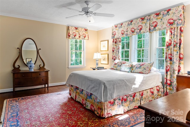 bedroom with crown molding, dark wood-type flooring, and ceiling fan