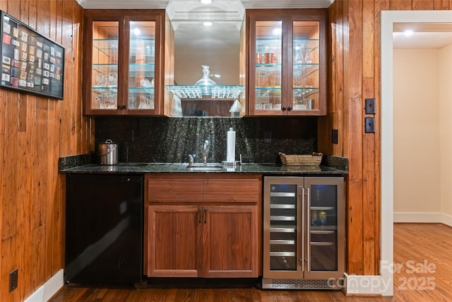 bar featuring wine cooler, dark stone counters, hardwood / wood-style floors, and decorative backsplash