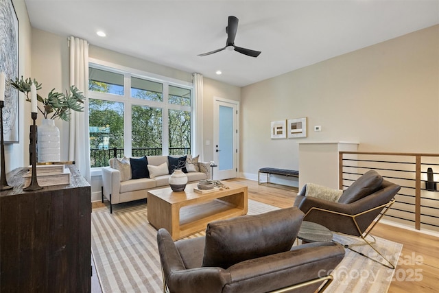 living room with light wood-type flooring and ceiling fan