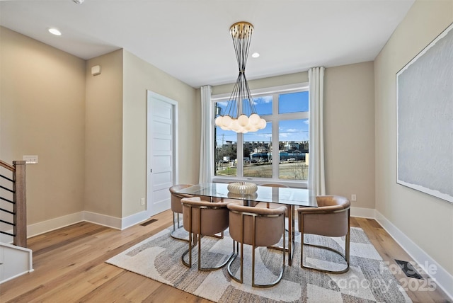 dining area featuring a notable chandelier and light hardwood / wood-style flooring