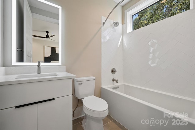 full bathroom with tile patterned floors, vanity, tiled shower / bath combo, ceiling fan, and toilet