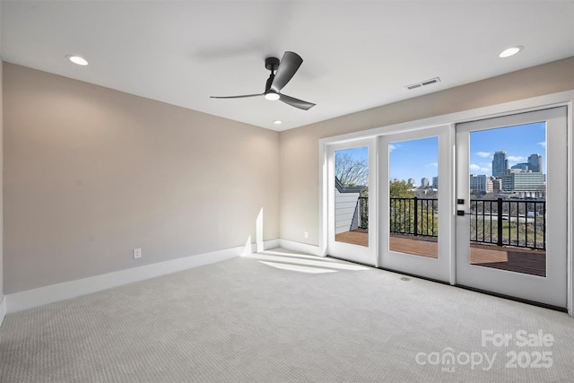 carpeted spare room featuring ceiling fan