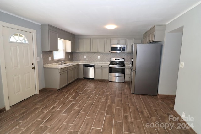 kitchen with gray cabinets, appliances with stainless steel finishes, tasteful backsplash, and sink