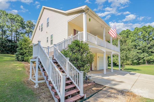 view of property exterior with a porch, a garage, and a yard