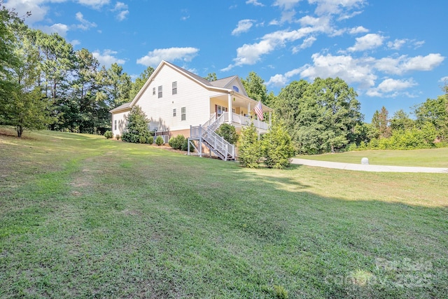 view of property exterior featuring a porch and a yard