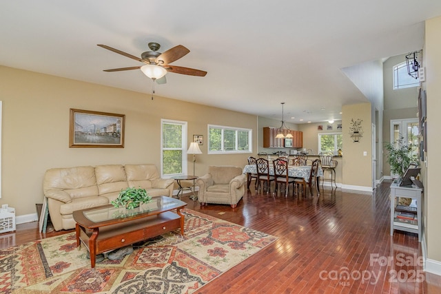 living room featuring dark hardwood / wood-style floors and ceiling fan with notable chandelier