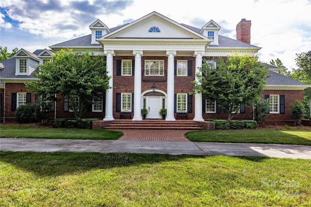 greek revival house featuring a front yard