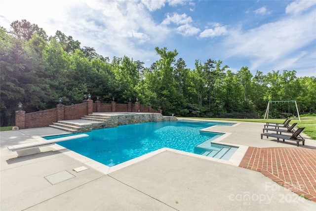 view of pool featuring a patio area and a diving board