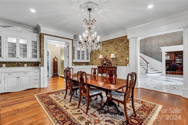 dining space with light hardwood / wood-style flooring, crown molding, and an inviting chandelier