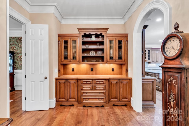 bar featuring light hardwood / wood-style floors, ornamental molding, and tasteful backsplash