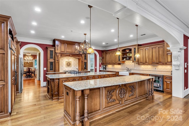 kitchen featuring decorative light fixtures, backsplash, beverage cooler, and a center island