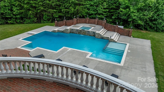 view of pool with an in ground hot tub and a yard