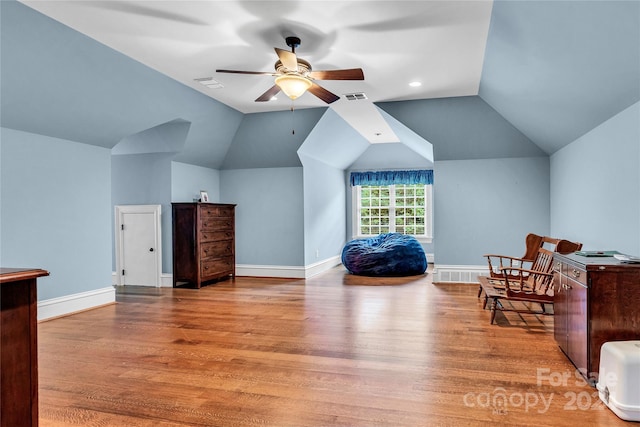 living area with ceiling fan, light hardwood / wood-style floors, and lofted ceiling