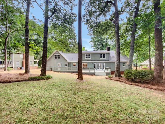 rear view of house featuring a wooden deck and a yard