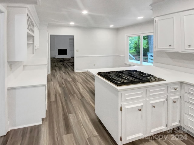 kitchen featuring dark wood-type flooring, stainless steel gas stovetop, and white cabinetry