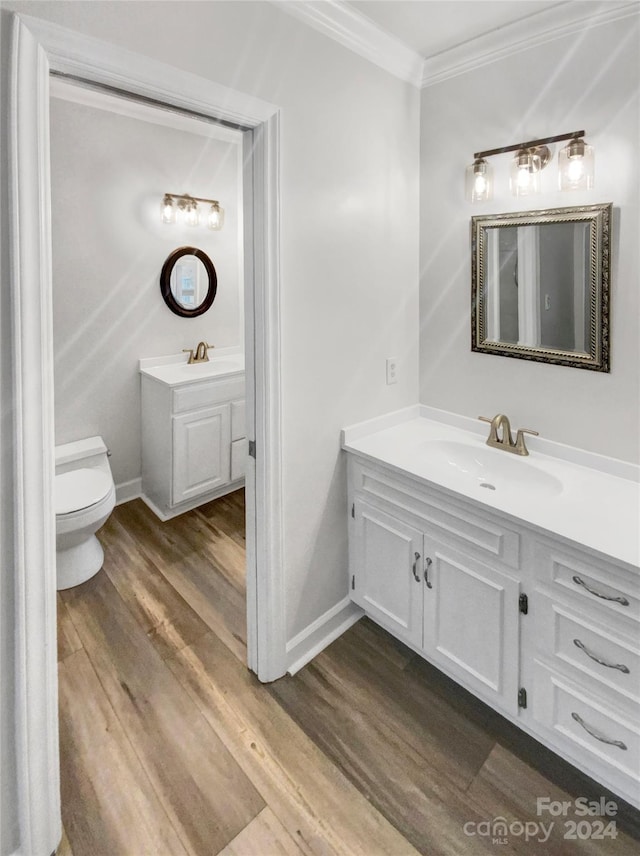 bathroom with hardwood / wood-style floors, toilet, vanity, and crown molding
