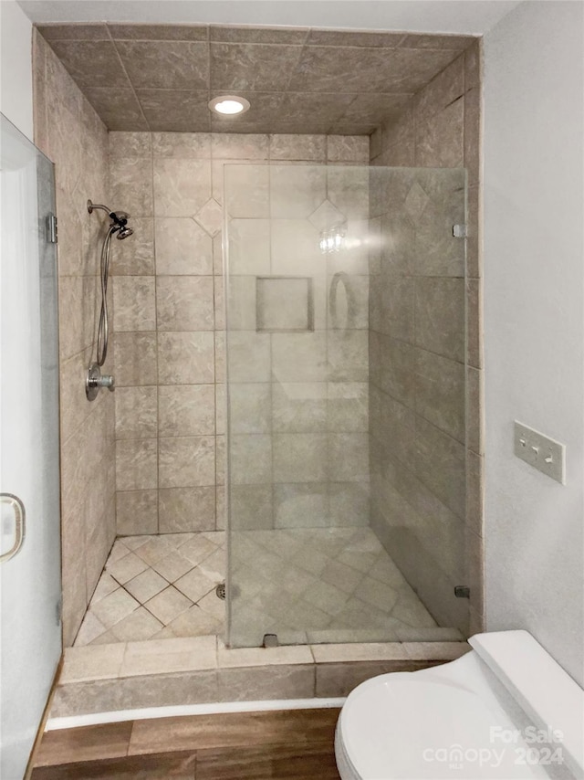 bathroom featuring toilet and a shower with door