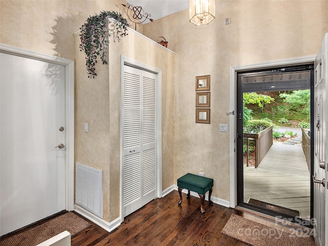 entrance foyer featuring dark hardwood / wood-style flooring and a chandelier