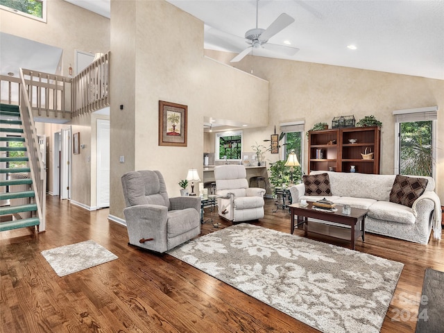 living room featuring dark hardwood / wood-style flooring, high vaulted ceiling, and ceiling fan