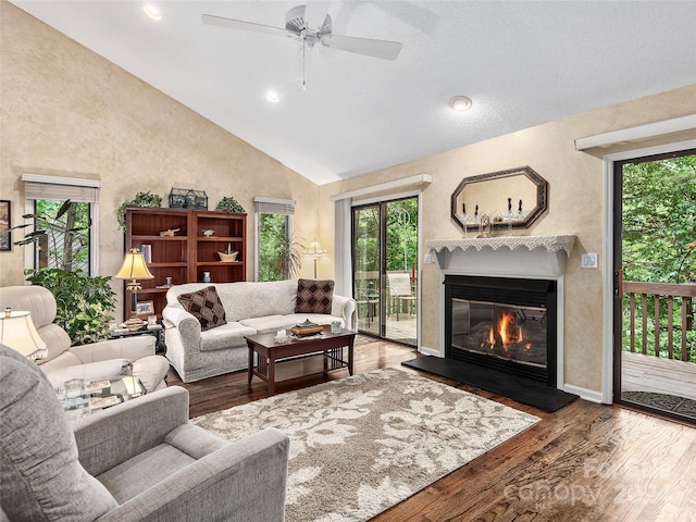 living room featuring ceiling fan, hardwood / wood-style floors, high vaulted ceiling, and a healthy amount of sunlight