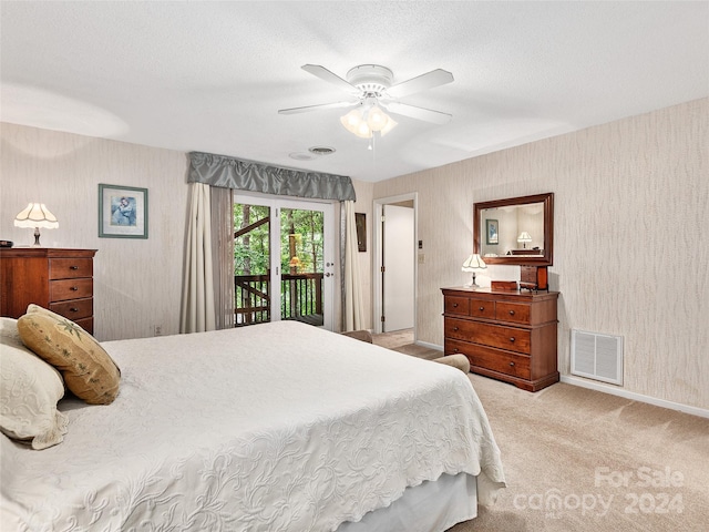 carpeted bedroom with a textured ceiling, access to outside, and ceiling fan