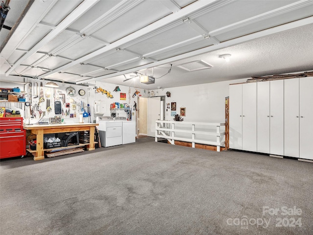 garage with a workshop area, a garage door opener, and independent washer and dryer