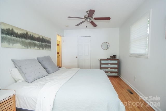 bedroom featuring ceiling fan, hardwood / wood-style flooring, and a closet