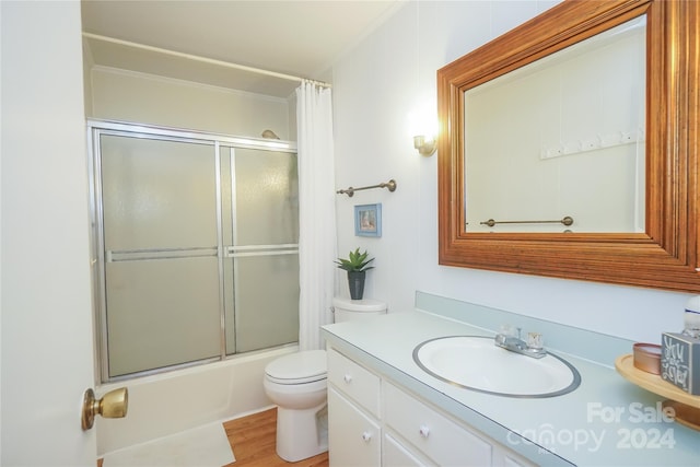 full bathroom featuring combined bath / shower with glass door, vanity, toilet, and hardwood / wood-style flooring