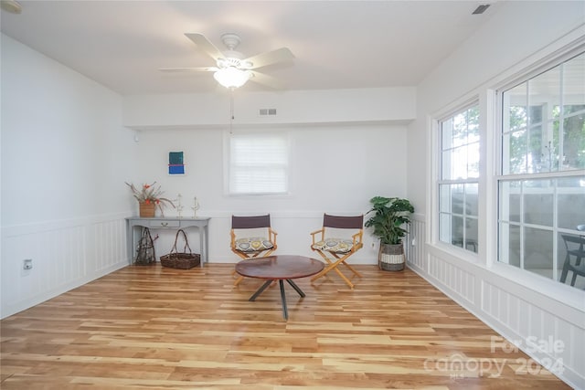 living area with ceiling fan and light hardwood / wood-style flooring