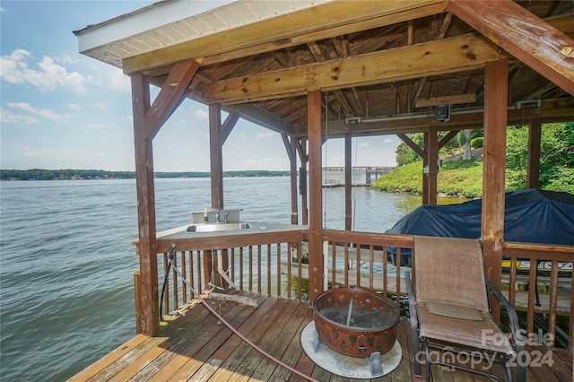 view of dock featuring a water view, an outdoor fire pit, and sink