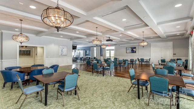 dining area with a chandelier, beam ceiling, hardwood / wood-style flooring, and coffered ceiling