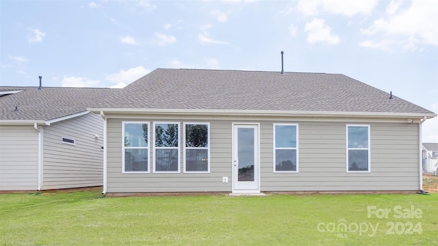 rear view of property featuring a lawn