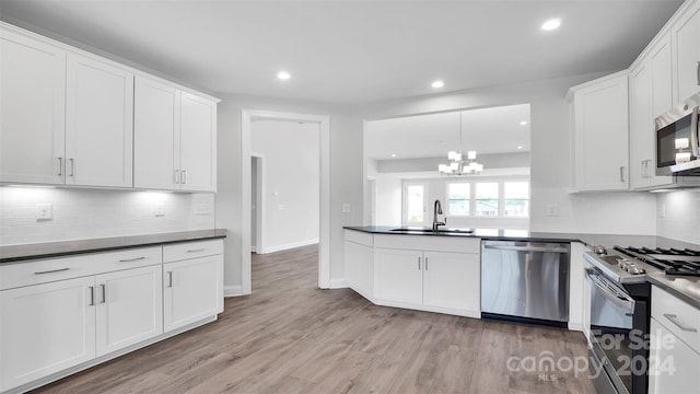 kitchen featuring light wood-type flooring, stainless steel appliances, white cabinetry, and sink