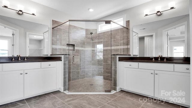 bathroom featuring tile patterned floors, vanity, and a shower with shower door