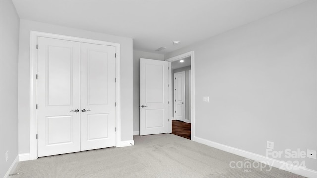 unfurnished bedroom with carpet floors and a closet