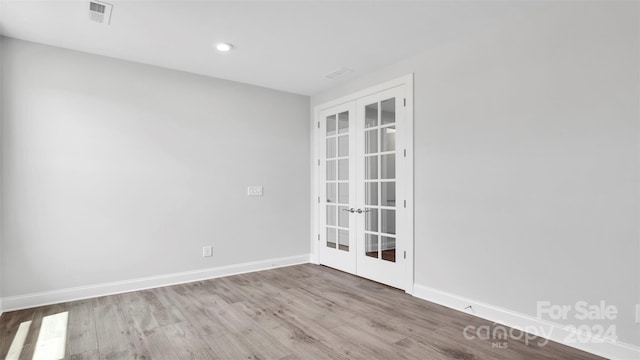 empty room with light wood-type flooring and french doors