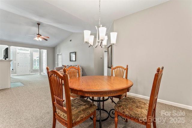 carpeted dining area featuring ceiling fan with notable chandelier and lofted ceiling