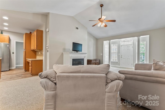 living room featuring ceiling fan and vaulted ceiling