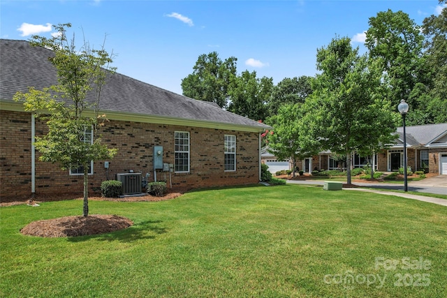 view of side of property with a lawn and central air condition unit