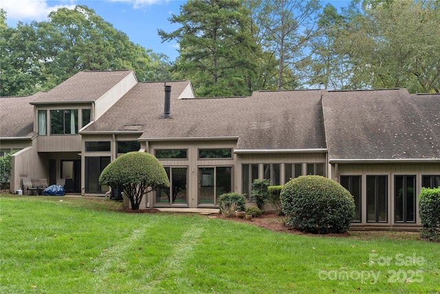 rear view of house featuring a lawn