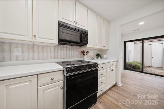 kitchen featuring white cabinetry, light hardwood / wood-style flooring, and black appliances