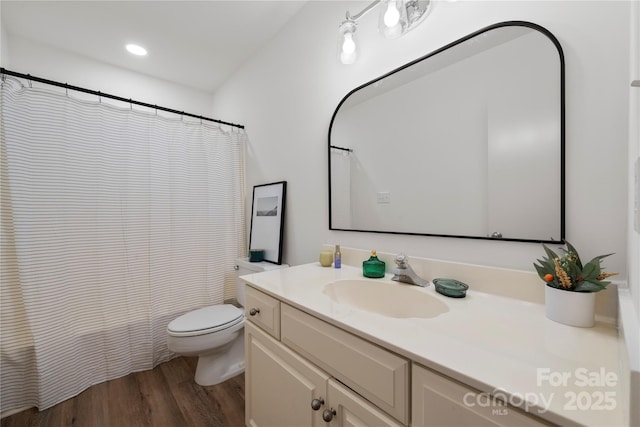 bathroom featuring vanity, hardwood / wood-style flooring, and toilet