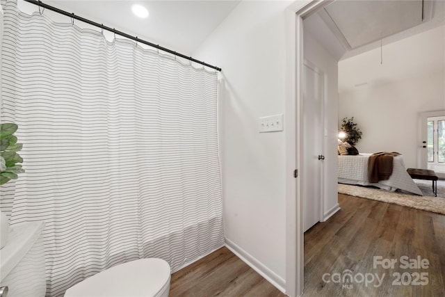 bathroom with hardwood / wood-style floors, toilet, and a shower with shower curtain