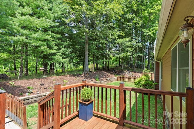 wooden deck featuring a lawn